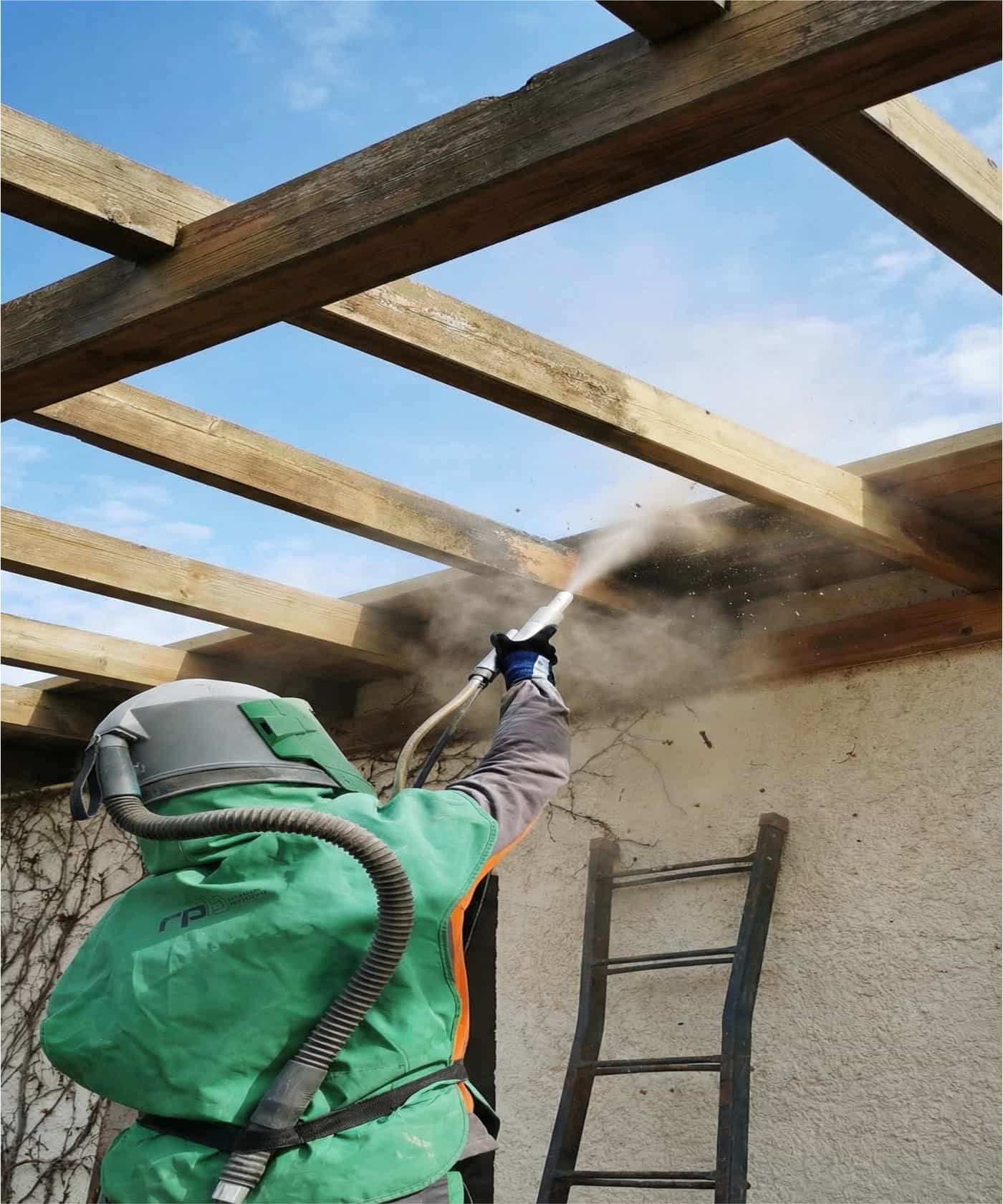 Operario realizando limpieza de techo/porche de madera en altura con equipo de protección y lanza.